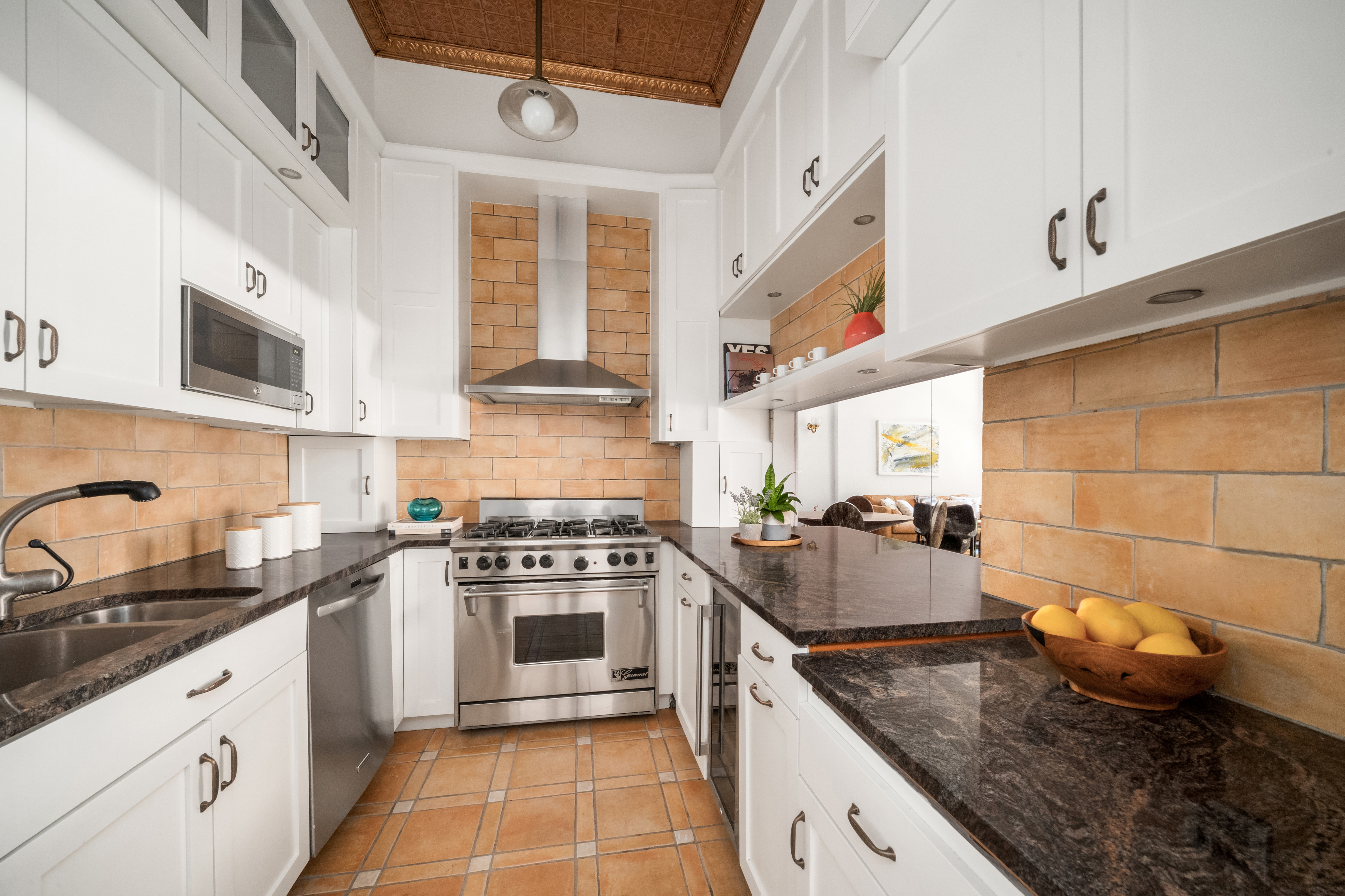 228 West 21st Street, Unit 2 Manhattan, NY 10011 - Photo 4 of 9 a large kitchen with stainless steel appliances granite countertop a stove a sink and a microwave
