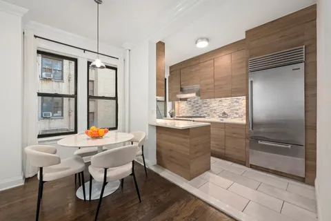 a kitchen with a table chairs refrigerator and window
