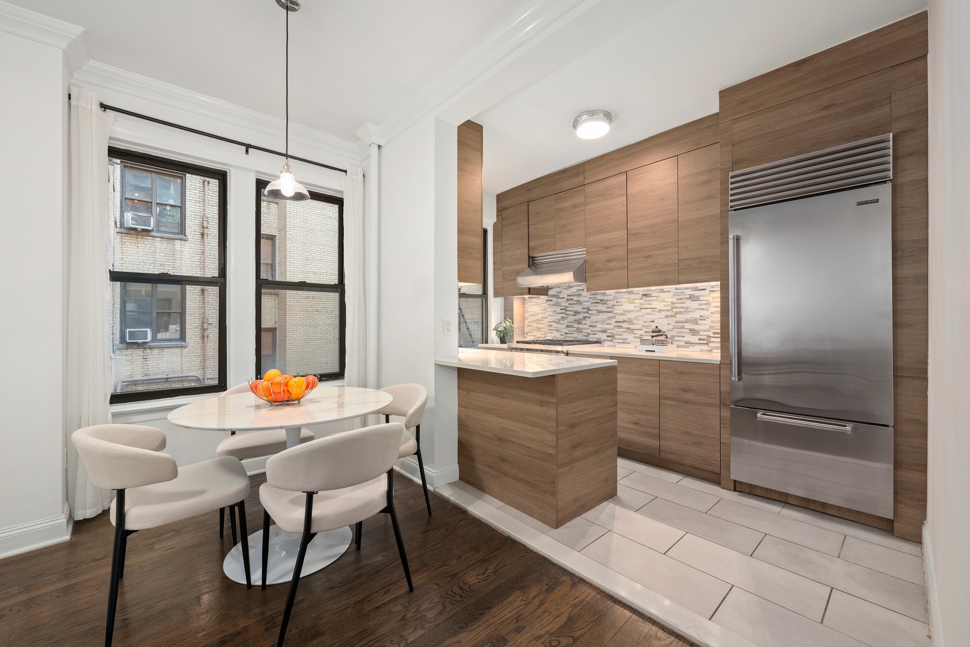 65 Morton Street, Unit 2N Manhattan, NY 10014 - Photo 2 of 12 a kitchen with a table chairs refrigerator and window