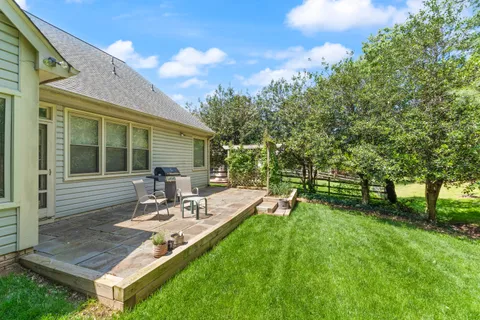 a view of a backyard with sitting area and garden