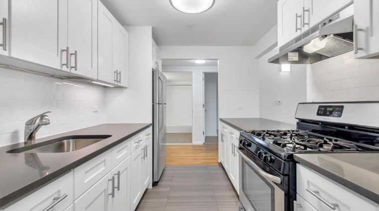 a kitchen with stainless steel appliances granite countertop a sink and a stove