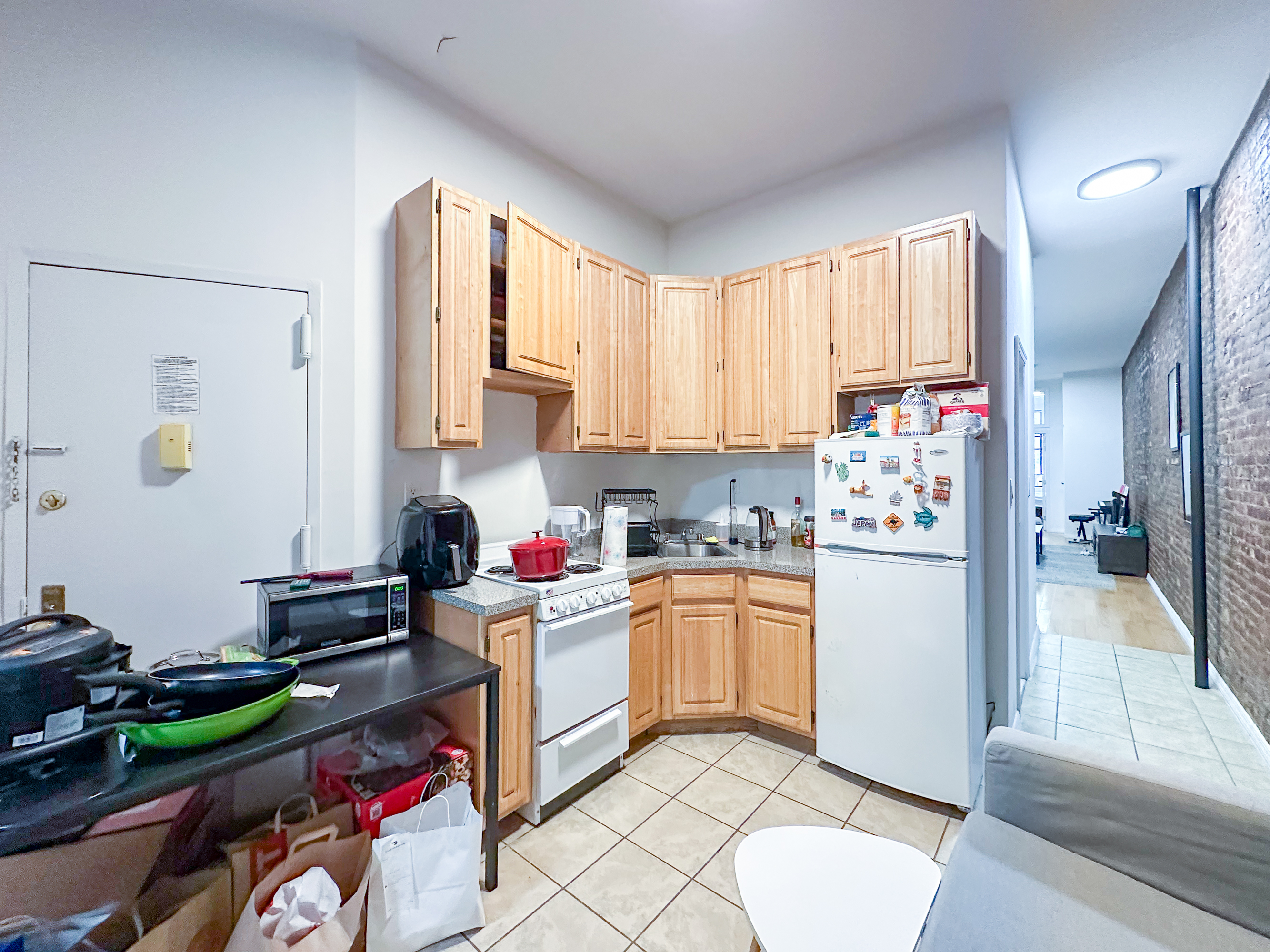 213 East 5th Street, Unit 1 Manhattan, NY 10003 - Photo 8 of 18 a kitchen with stainless steel appliances granite countertop a refrigerator sink and stove