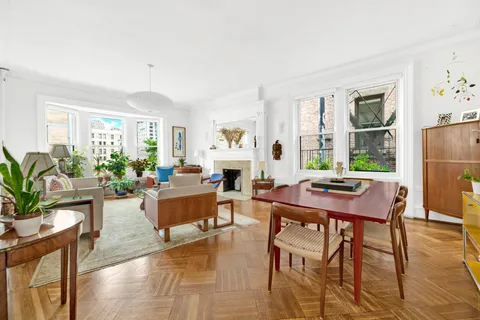 a living room with furniture dining table a window and appliances