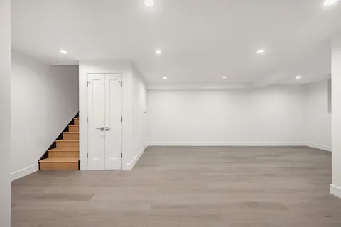 an empty room with wooden floor and stairs