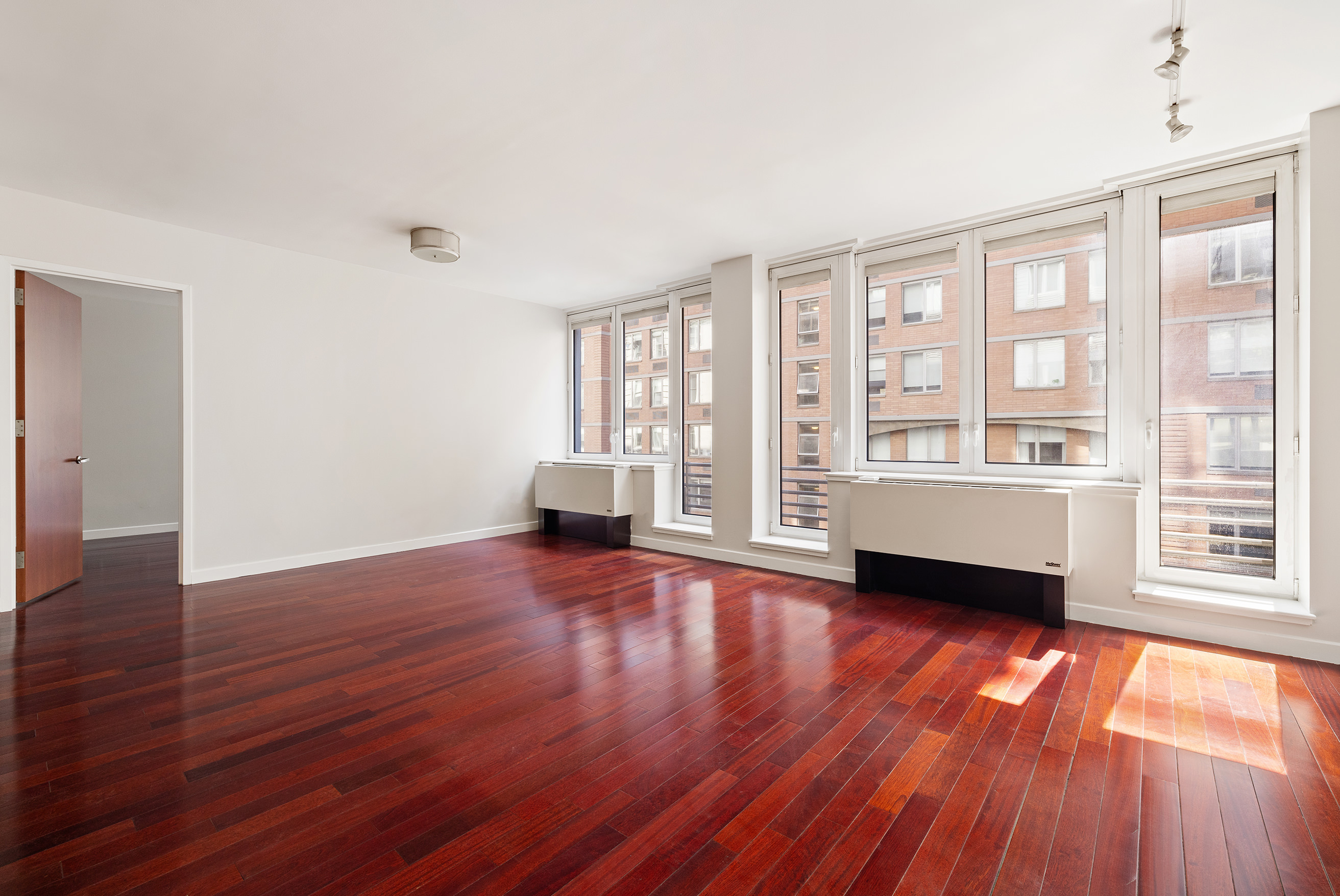 125 West 21st Street, Unit 5B Manhattan, NY 10011 - Photo 3 of 15 a view of an empty room with wooden floor and a window