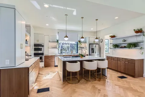 a kitchen with kitchen island granite countertop wooden cabinets and stainless steel appliances