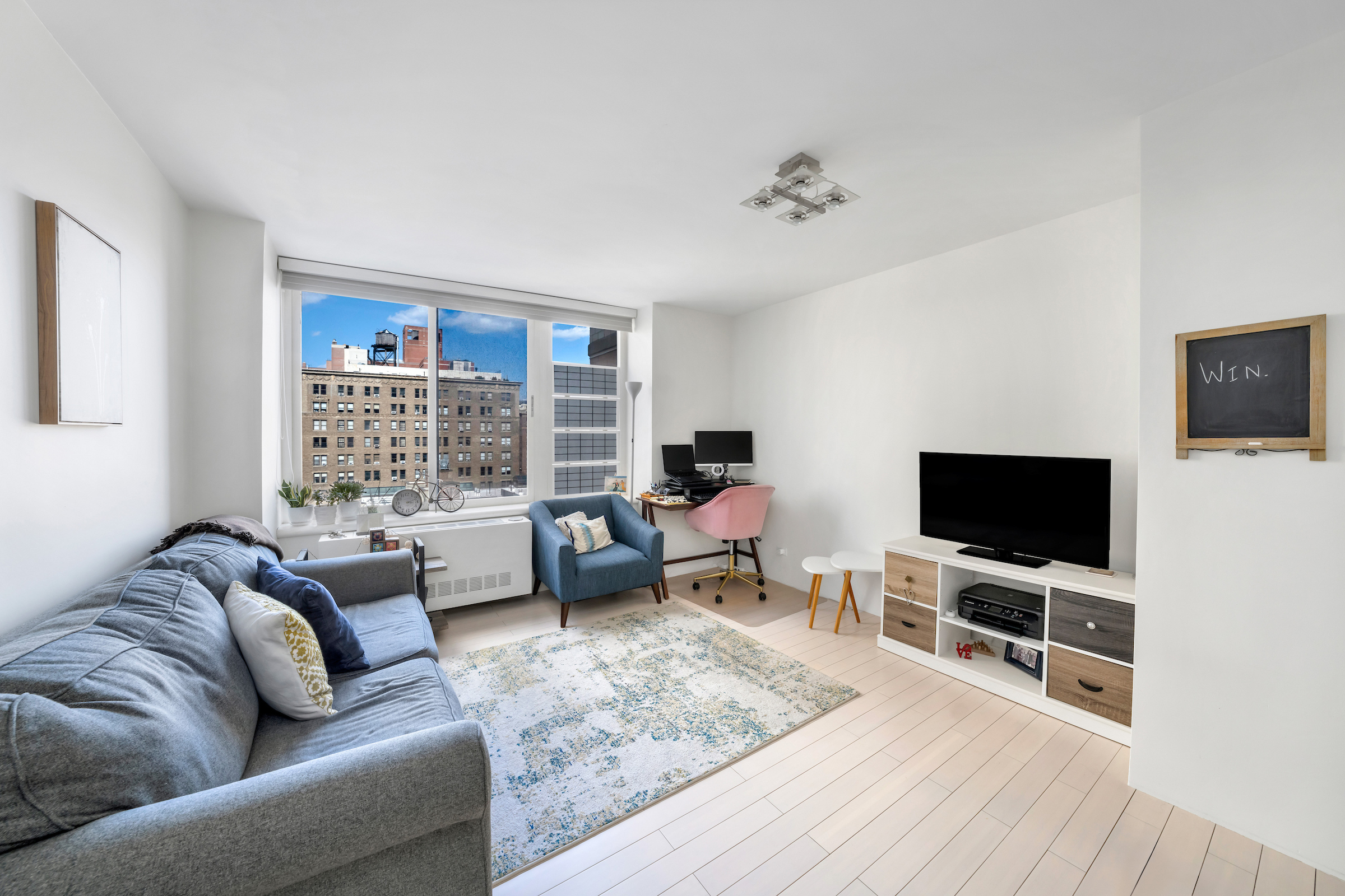 2373 Broadway, Unit 1425 Manhattan, NY 10024 - Photo 2 of 13 a living room with furniture and a flat screen tv