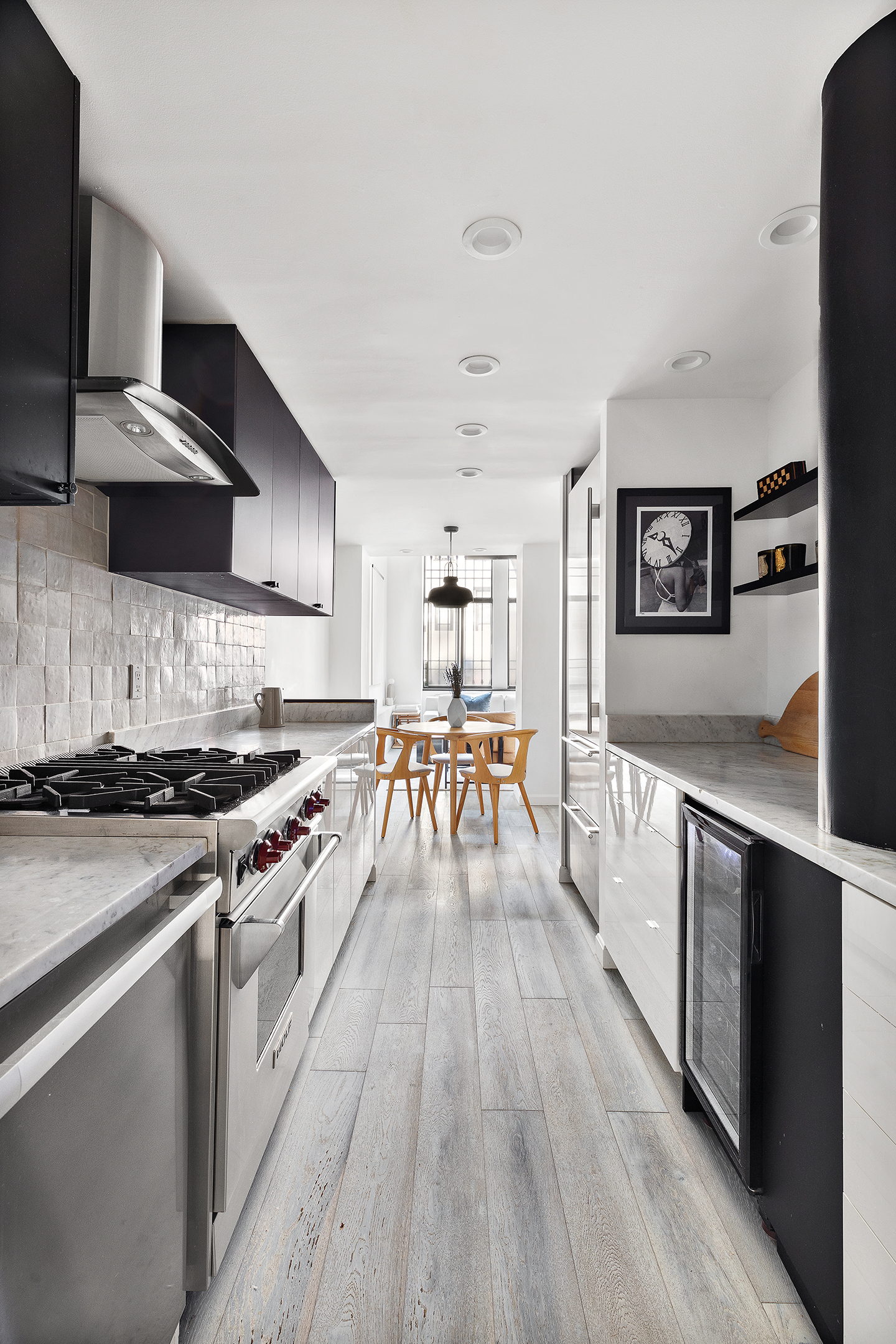155 West 15th Street, Unit 1J Manhattan, NY 10011 - Photo 5 of 13 a large kitchen with stainless steel appliances granite countertop a stove and a refrigerator
