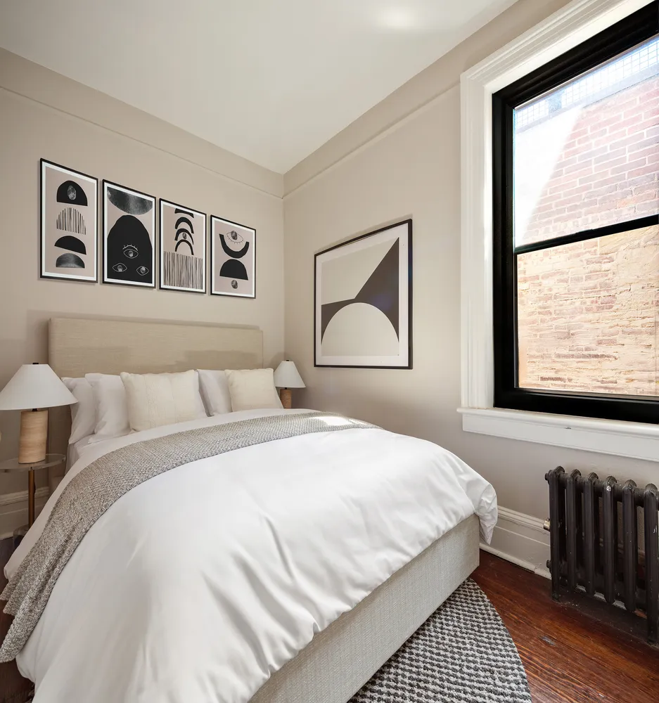 a bedroom with a bed and a painting on the wall