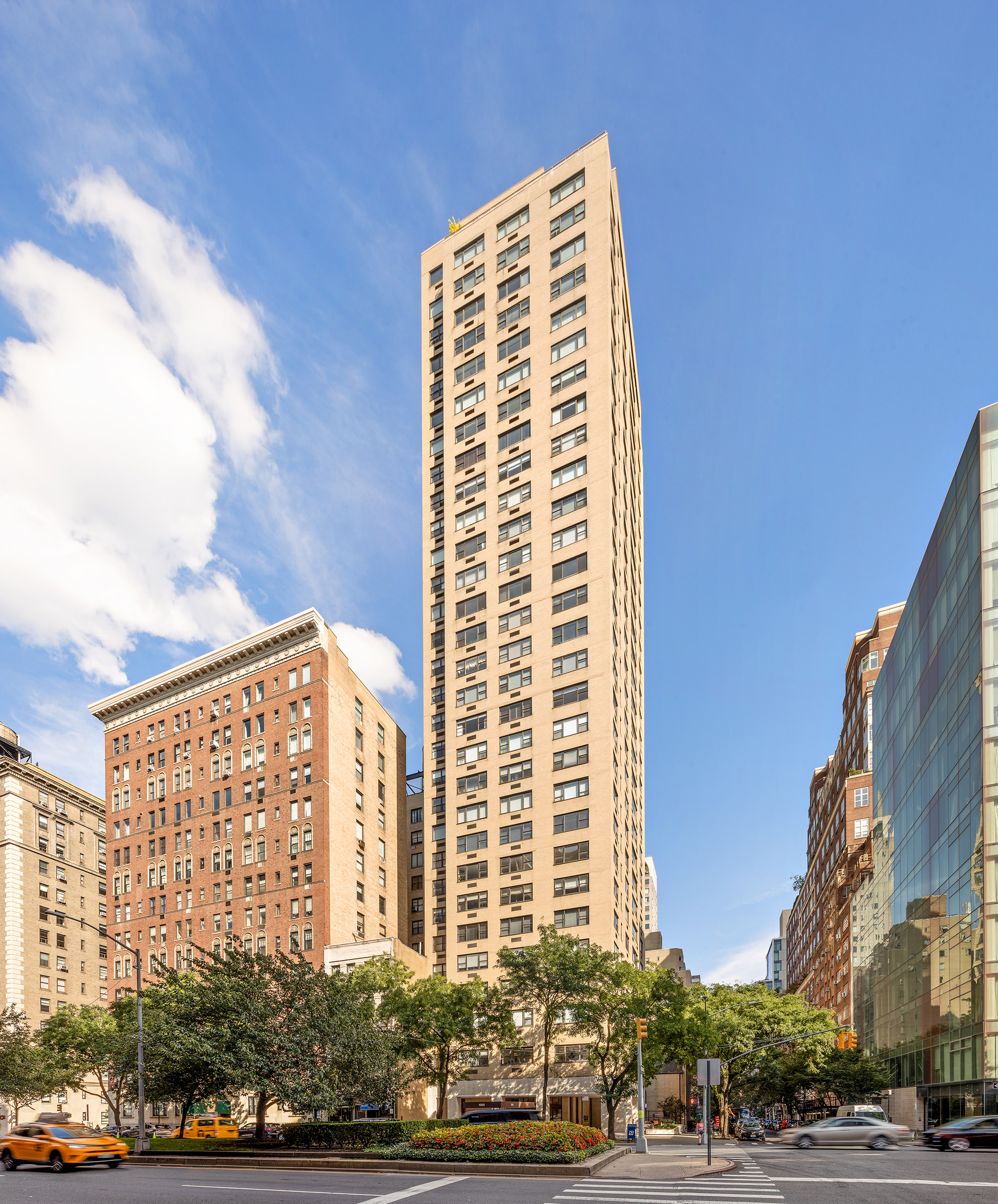 1065 Park Avenue, Unit 5BC Manhattan, NY 10128 - Photo 15 of 16 a front view of a building with lot of cars and trees