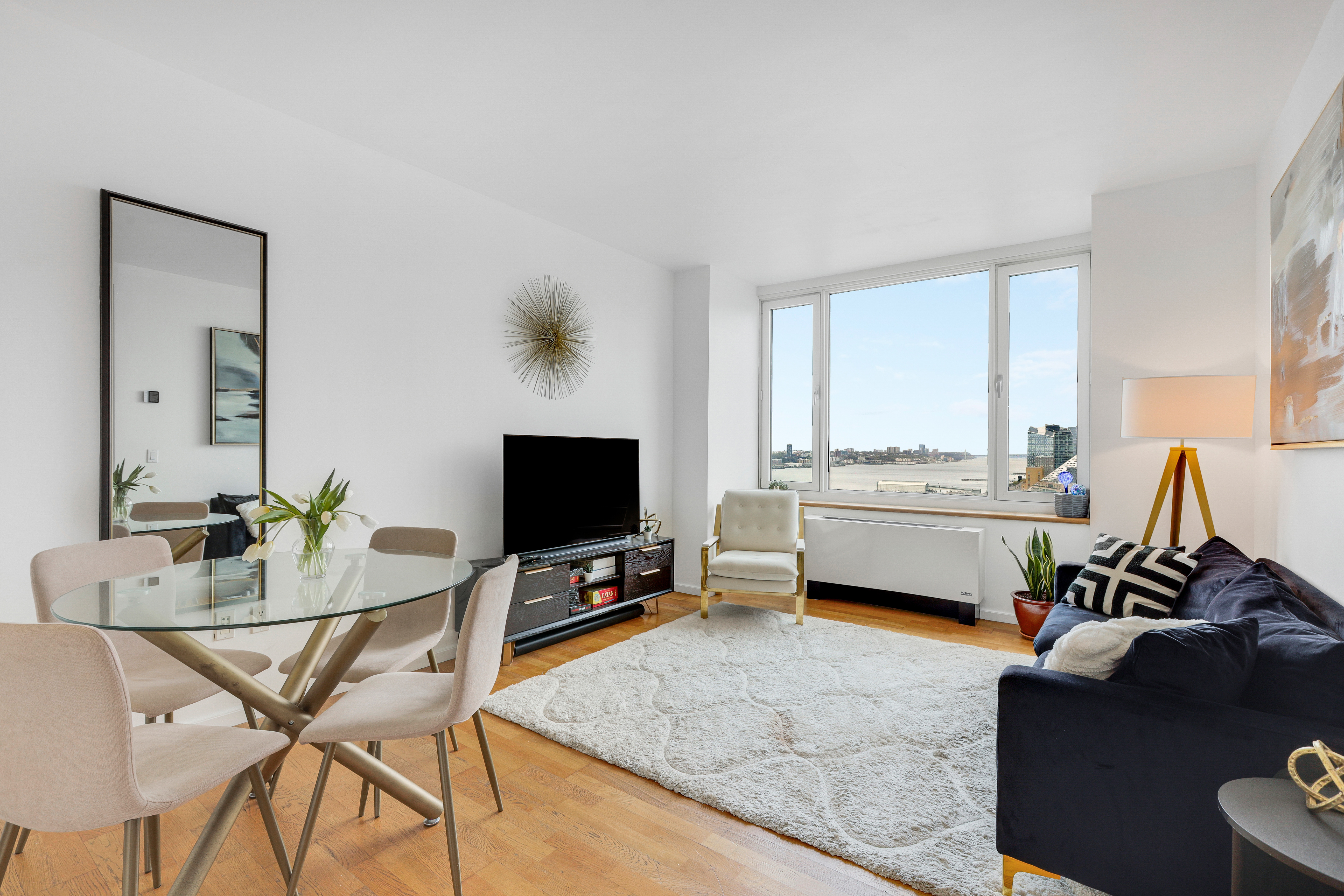 635 West 42nd Street, Unit 25D Manhattan, NY 10036 - Photo 1 of 18 a living room with furniture and a flat screen tv
