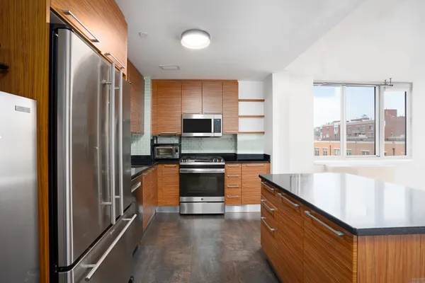 a kitchen with stainless steel appliances granite countertop a refrigerator and a stove top oven