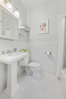 a bathroom with a sink mirror and toilet