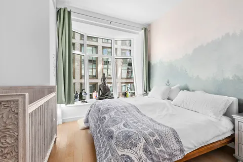 a bedroom with a bed and a large window