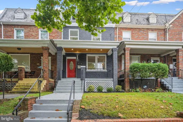 front view of a brick house with a yard