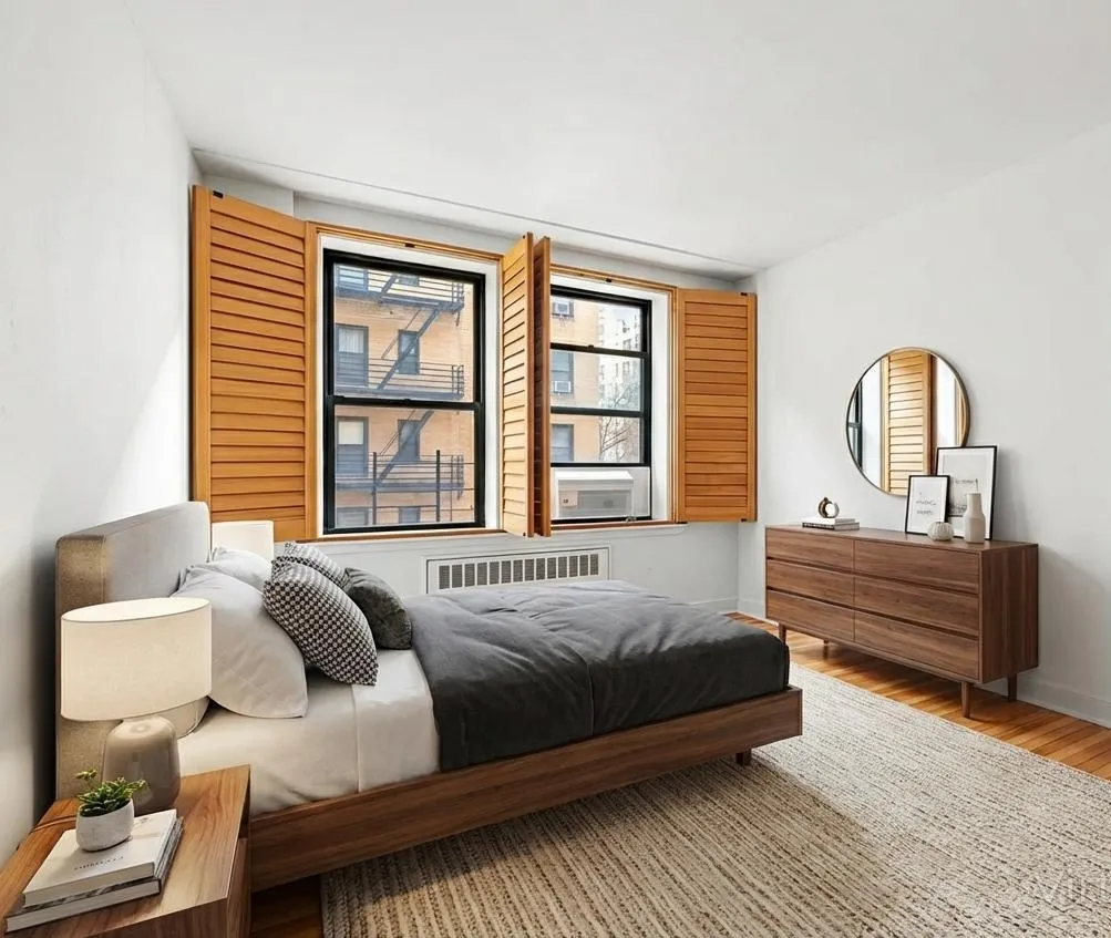 a bedroom with a bed wooden floor and window