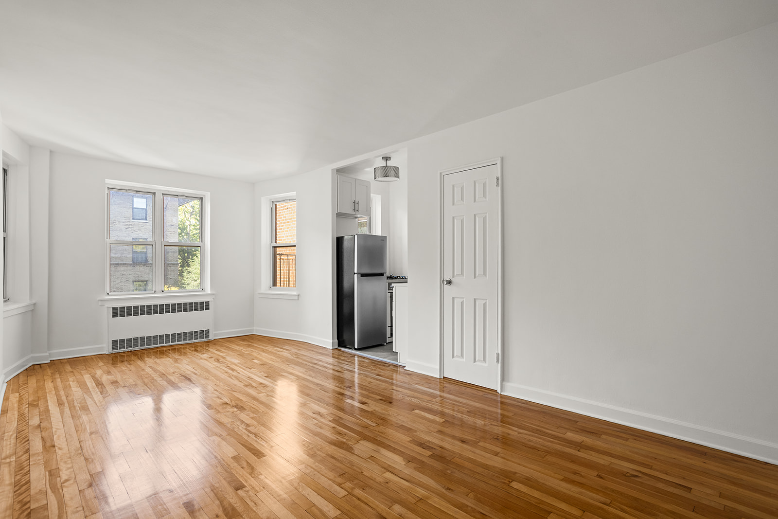 33-35 81st Street, Unit 5A Queens, NY 11372 - Photo 2 of 12 a view of an empty room with wooden floor and a window