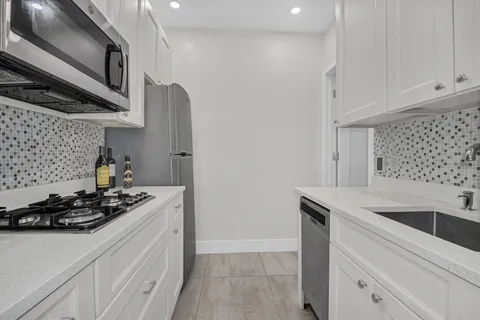 a kitchen with stainless steel appliances granite countertop a sink stove and cabinets