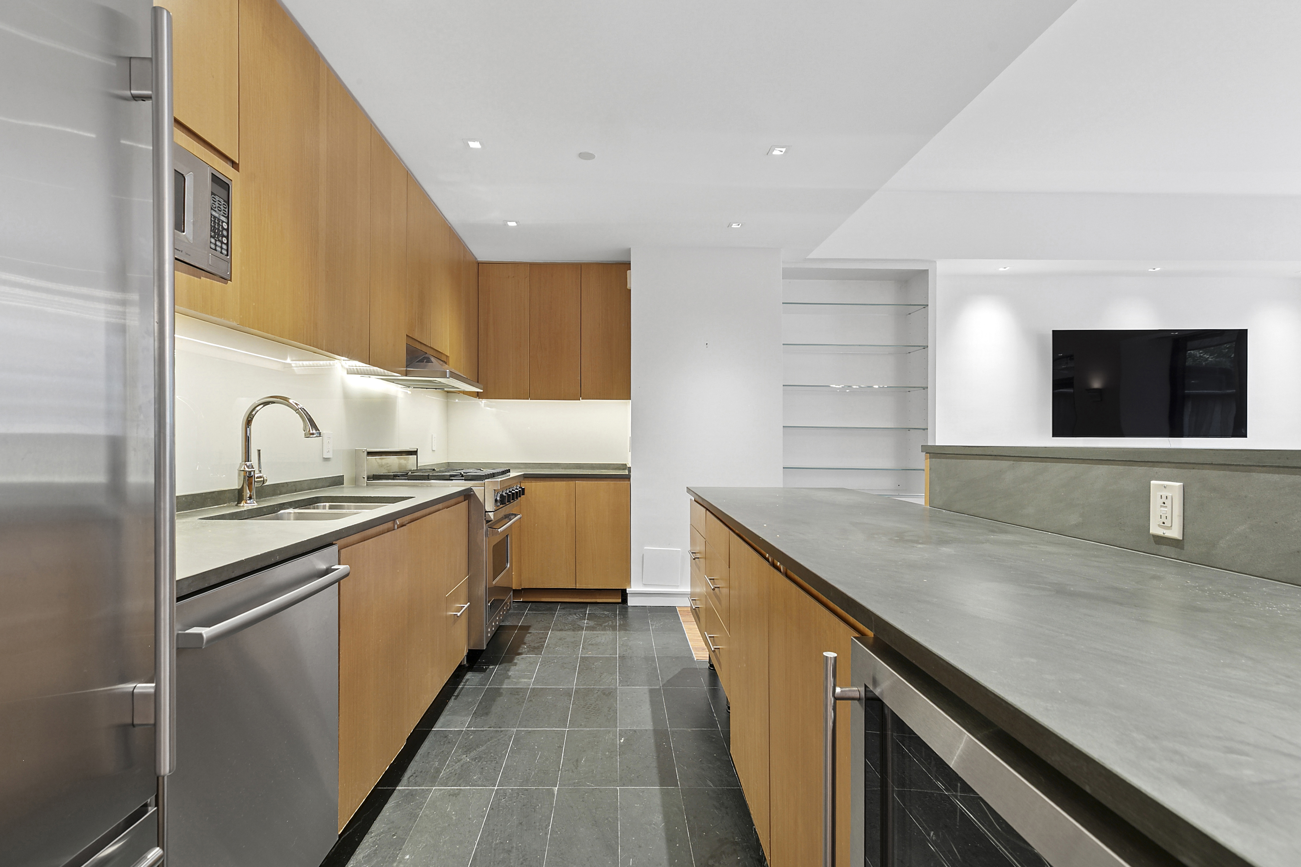 255 Hudson Street, Unit TH1 Manhattan, NY 10013 - Photo 4 of 10 a kitchen with stainless steel appliances granite countertop a sink and a stove