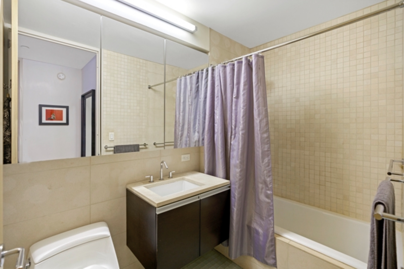 110 3rd Avenue, Unit 9B Manhattan, NY 10003 - Photo 9 of 14 a bathroom with a sink a toilet and shower