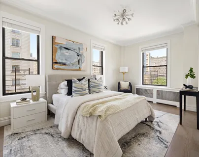 a spacious bedroom with a bed and wooden floor