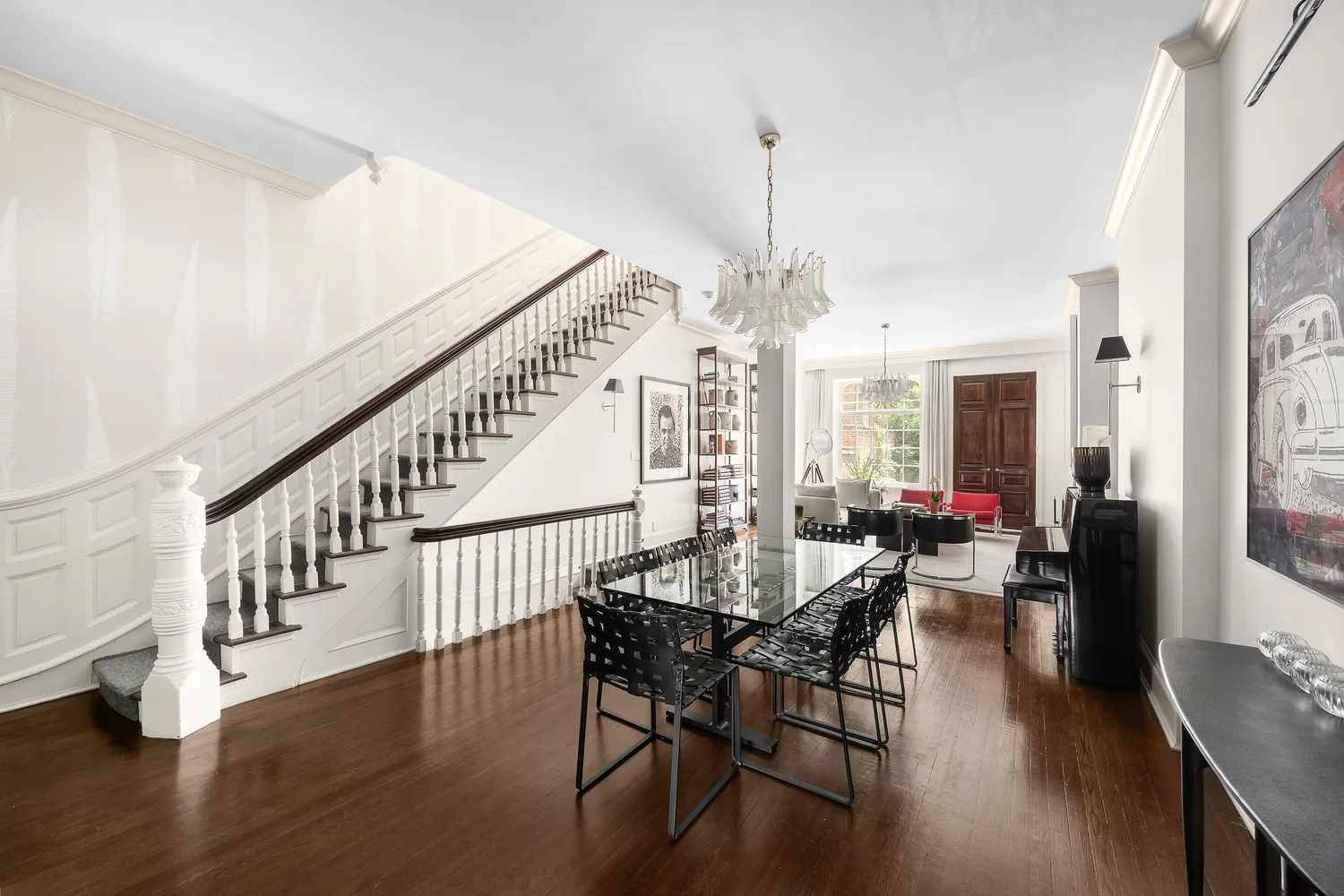 a view of a dining room and livingroom with furniture wooden floor a chandelier