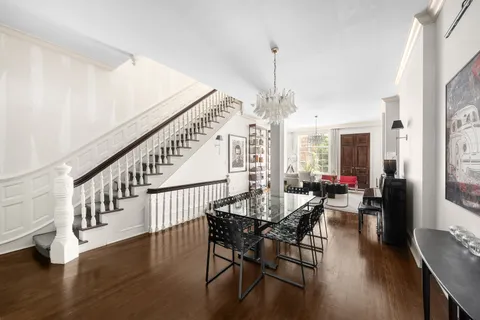 a view of a dining room and livingroom with furniture wooden floor a chandelier