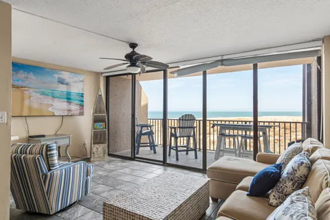 a living room with furniture and a floor to ceiling window