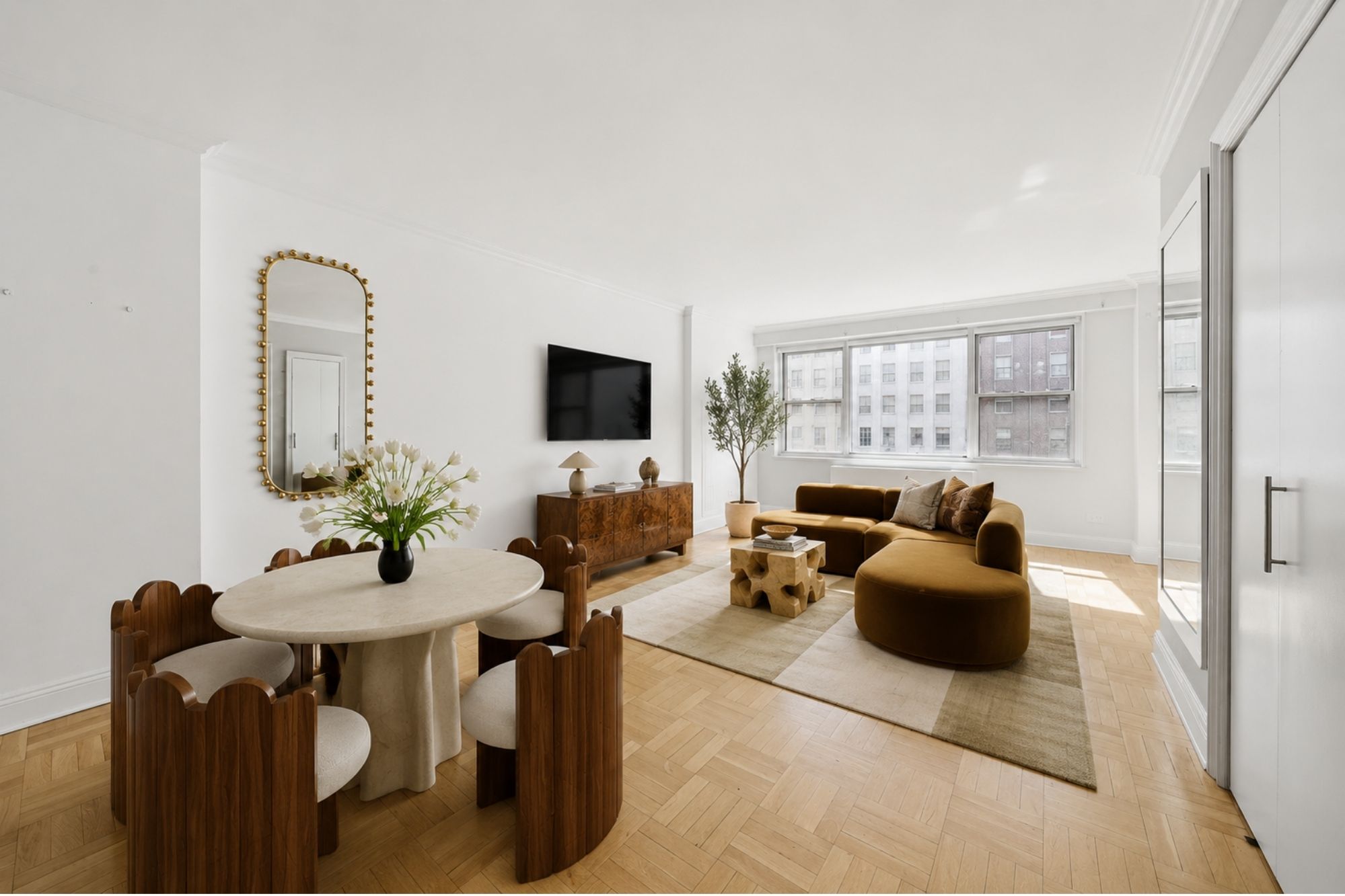 150 East 61st Street, Unit 8K Manhattan, NY 10065 - Photo 2 of 7 a living room with furniture and a flat screen tv