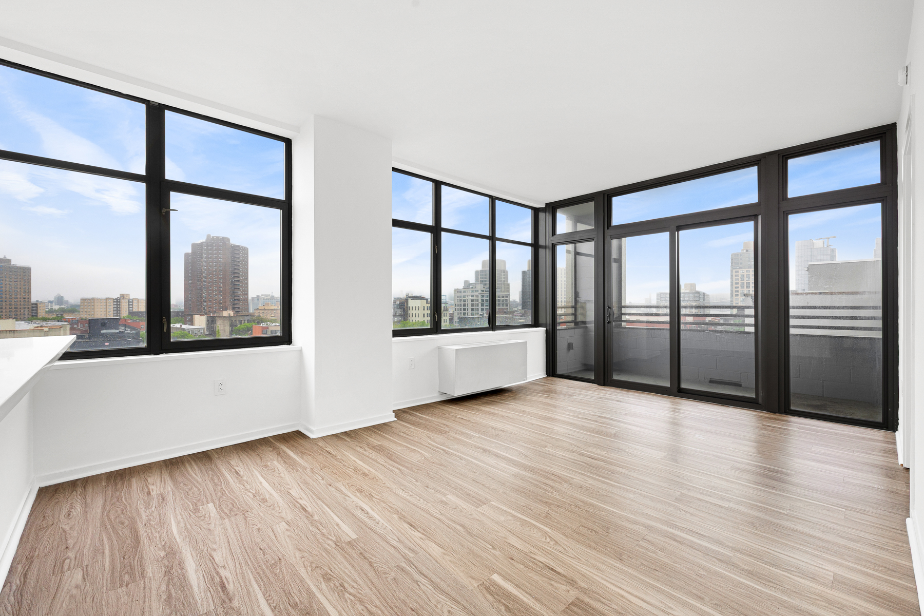 424 Bedford Avenue, Unit 6B Brooklyn, NY 11249 - Photo 4 of 11 a view of an empty room with wooden floor and a window