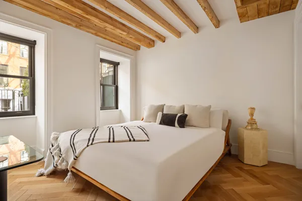 a bedroom with a bed and wooden floor