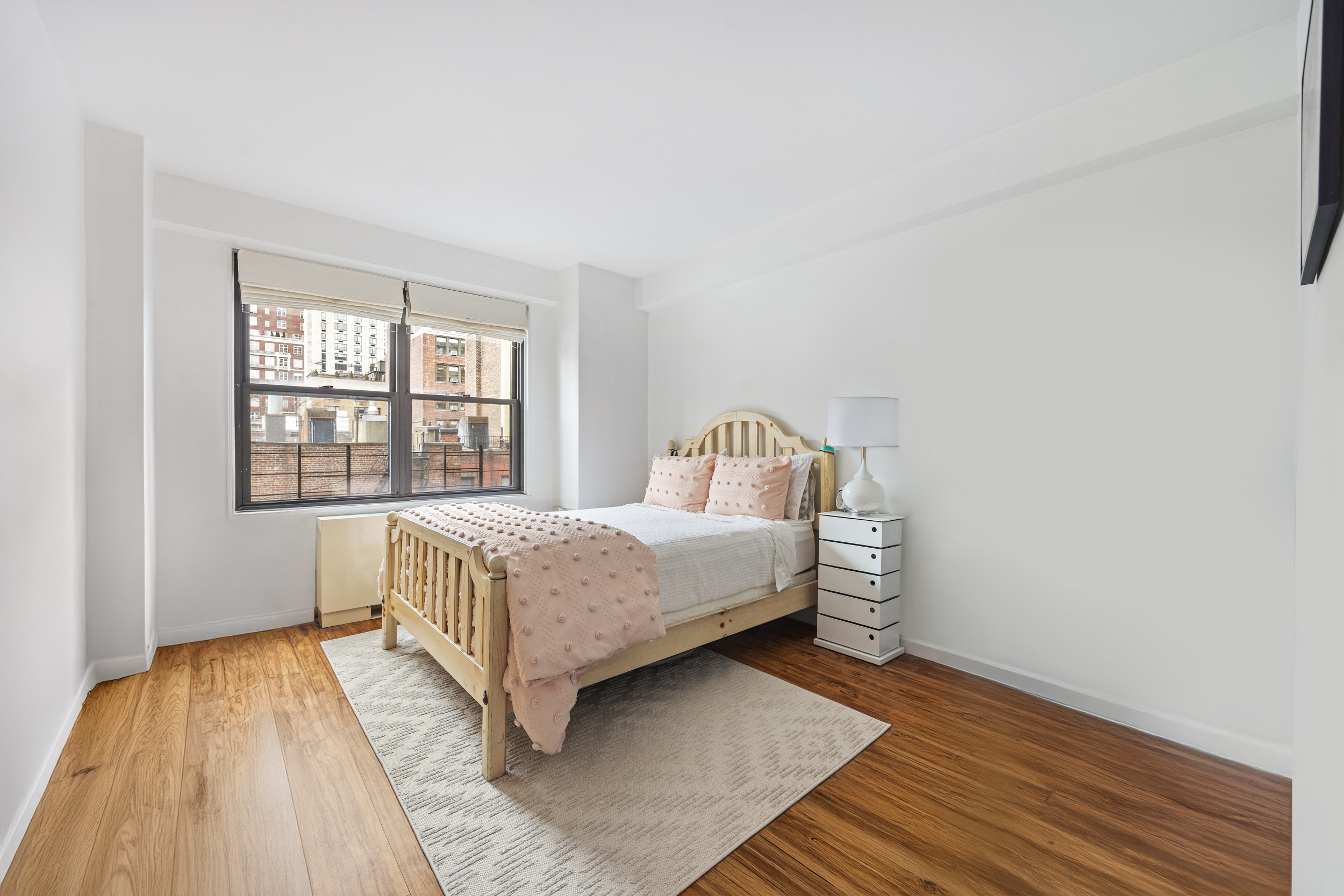 120 East 90th Street, Unit 7B Manhattan, NY 10128 - Photo 5 of 8 a bedroom with a bed and wooden floor