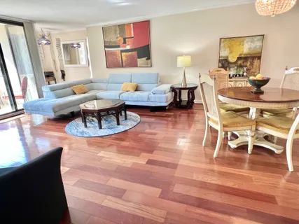 a living room with furniture a flat screen tv and a table