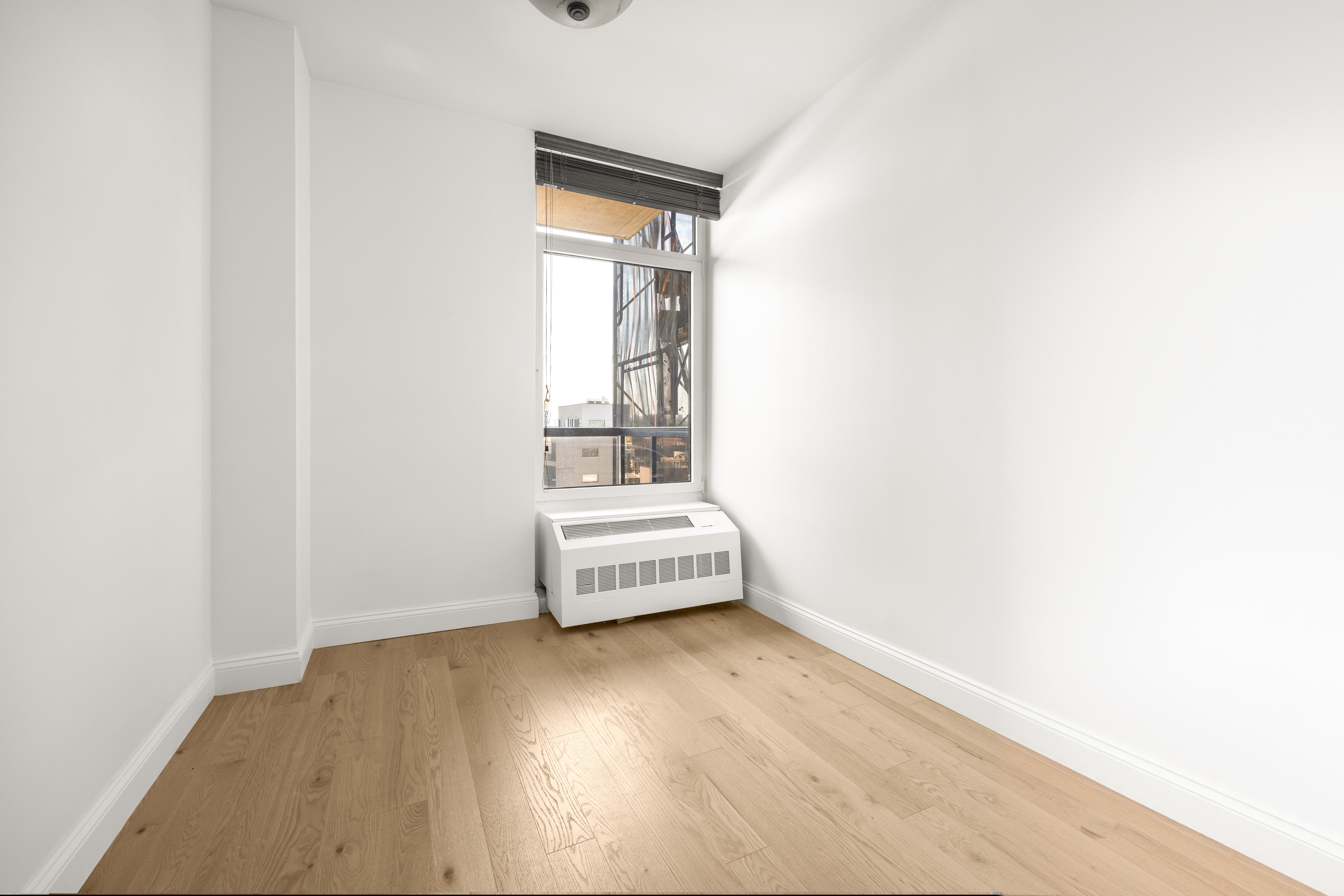 162 16th Street, Unit 7E Brooklyn, NY 11215 - Photo 21 of 23 a view of an empty room with wooden floor and a window