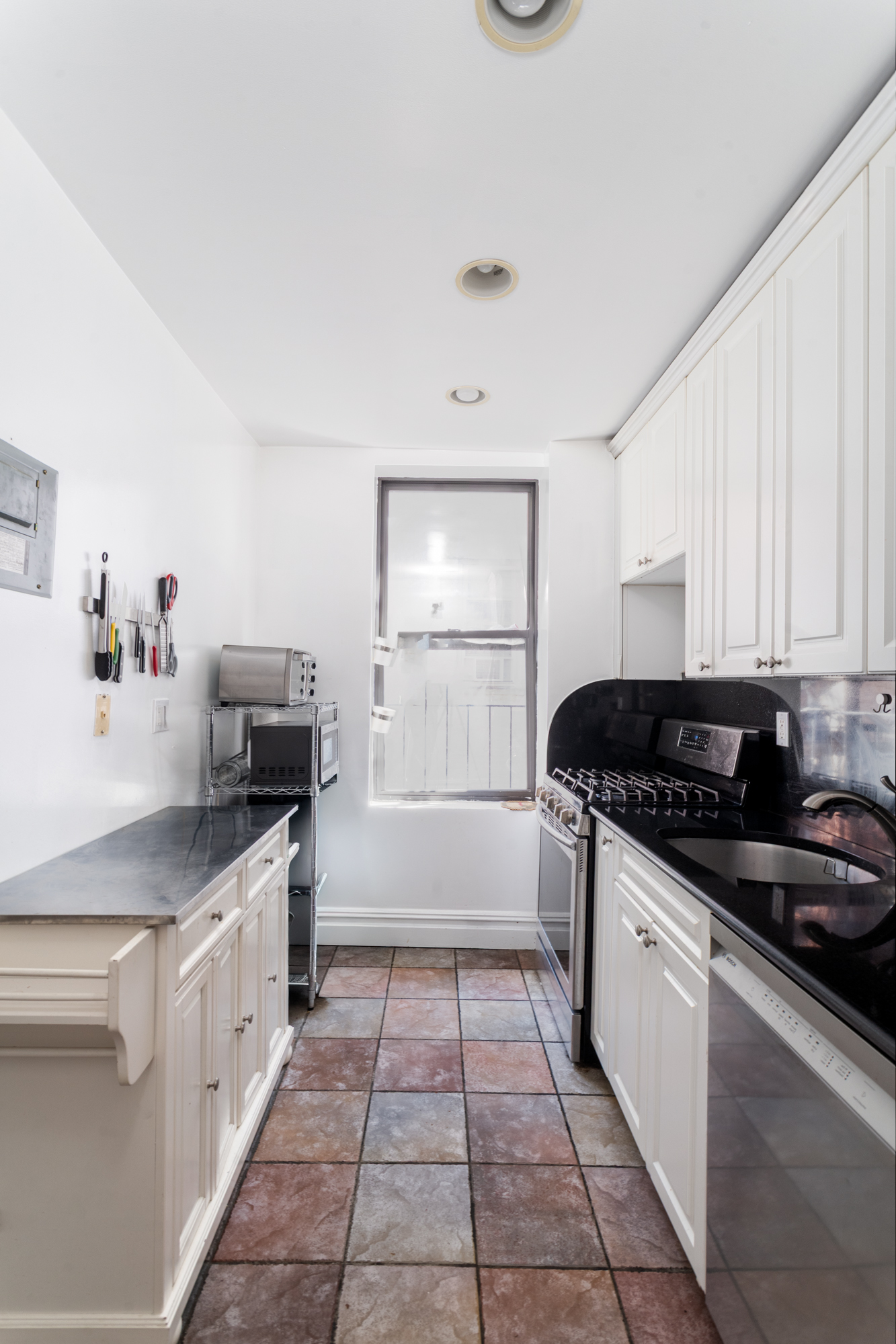750 Riverside Drive, Unit 4E Manhattan, NY 10031 - Photo 5 of 11 a kitchen with a sink a stove and cabinets