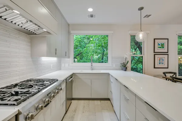 a kitchen with a sink stove top oven and cabinets