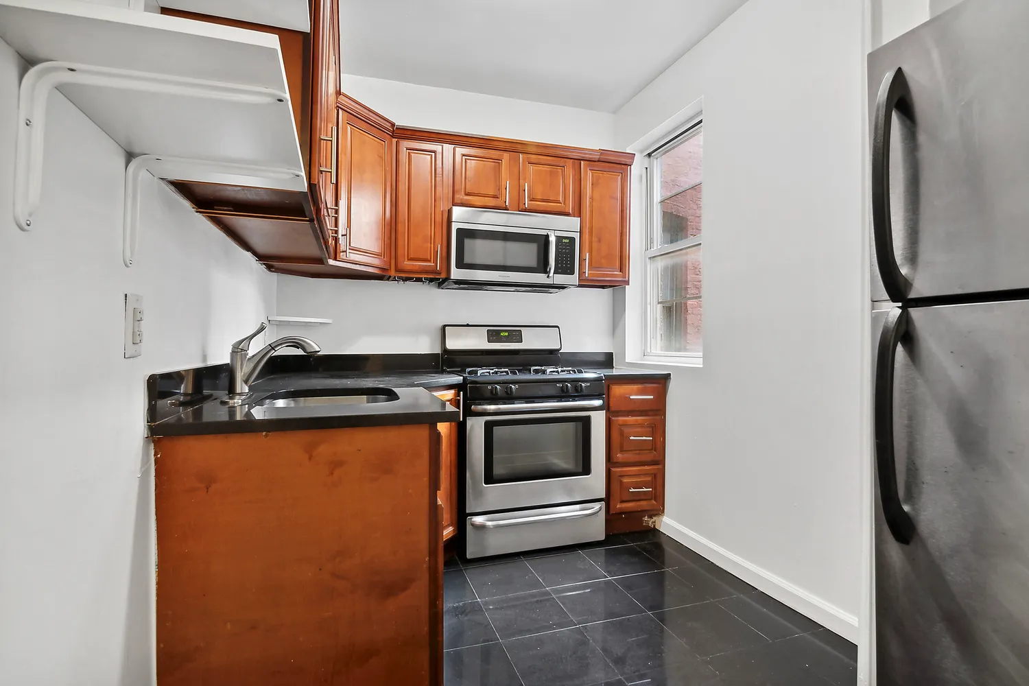 a kitchen with stainless steel appliances granite countertop a refrigerator stove a sink and a microwave