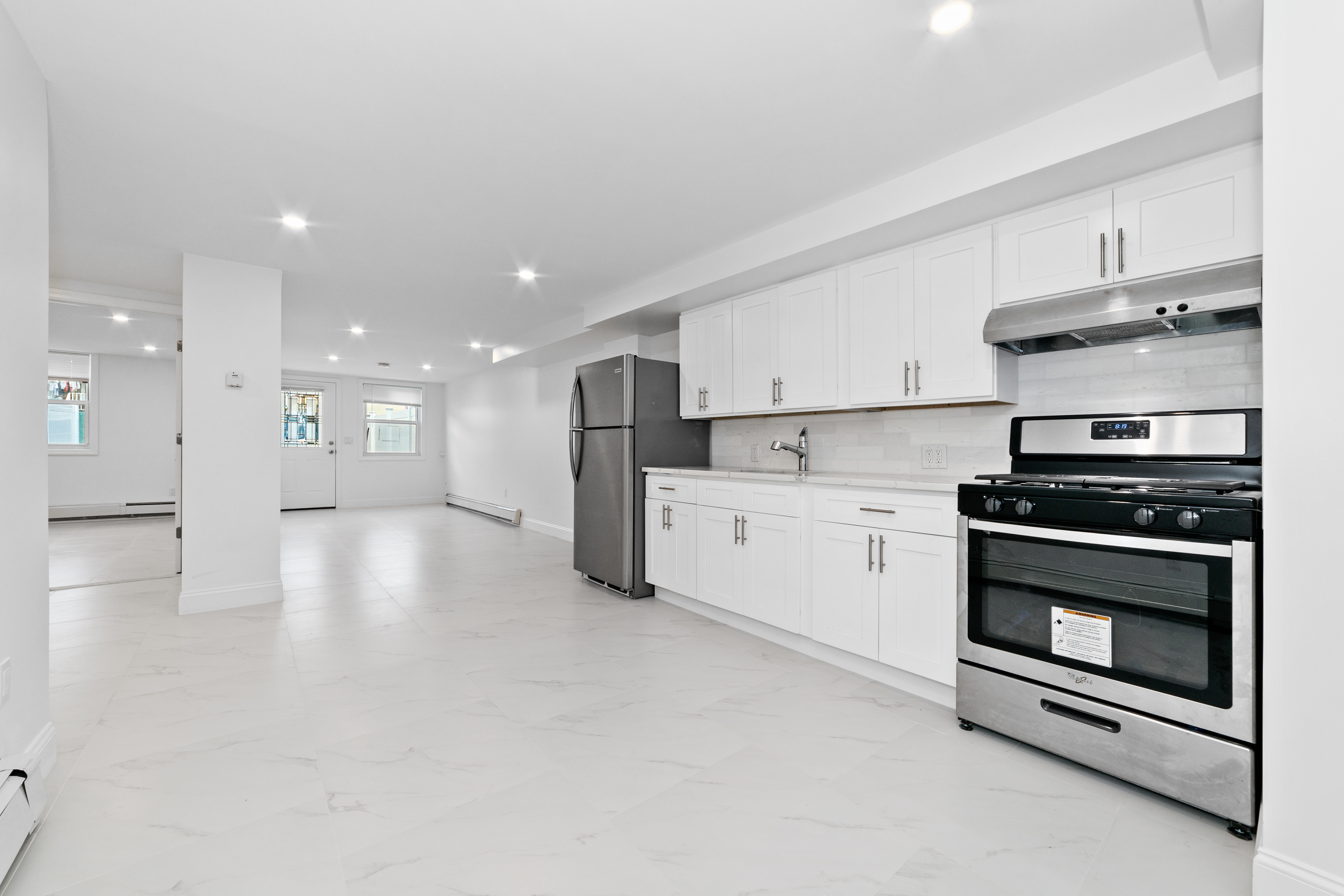 24-41 82nd Street Queens, NY 11370 - Photo 11 of 15 a kitchen with stainless steel appliances kitchen island granite countertop a stove a sink and a refrigerator