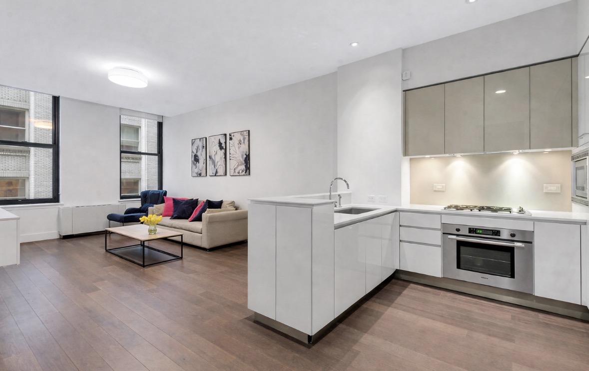 25 Broad Street, Unit 11K Manhattan, NY 10004 - Photo 1 of 16 a living room with furniture and kitchen view