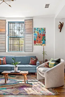 a living room with furniture and painting on the wall
