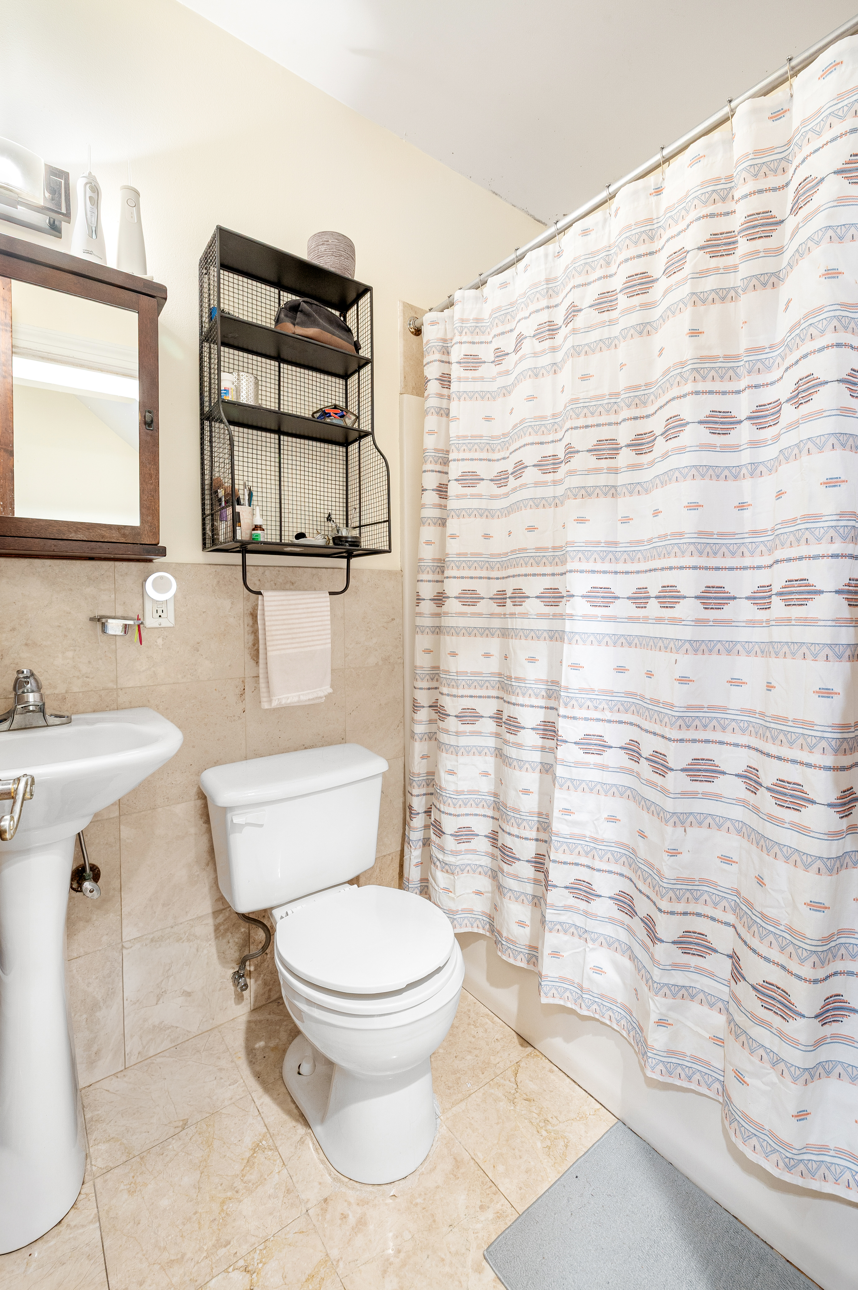 518 West 149th Street Manhattan, NY 10031 - Photo 9 of 23 a bathroom with a sink a toilet and shower curtain