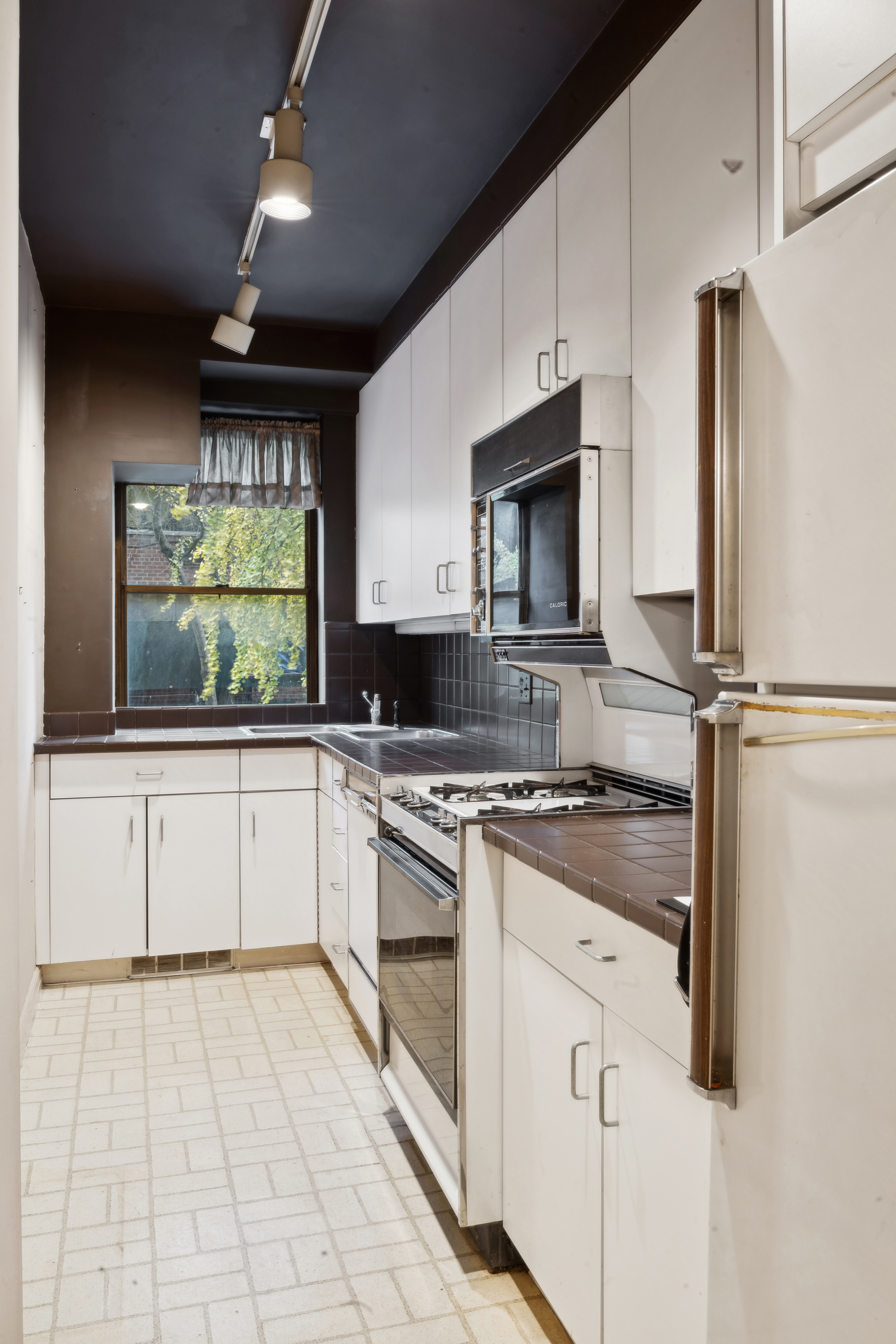 12 Beekman Place, Unit 2F Manhattan, NY 10022 - Photo 2 of 7 a kitchen with stainless steel appliances granite countertop a stove a sink and a microwave