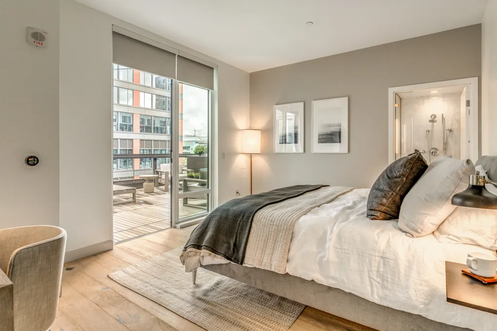 a bedroom with a balcony a bed and wooden floor