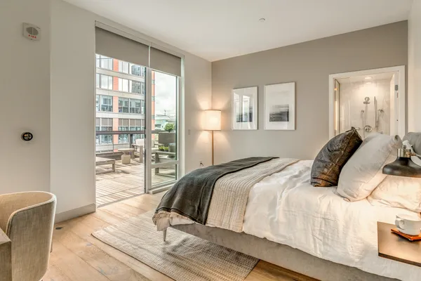 a bedroom with a balcony a bed and wooden floor