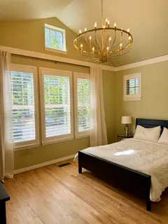 a bedroom with a bed and a chandelier