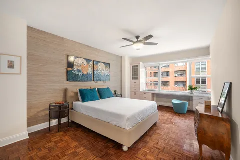 a bedroom with a bed a large window and walk in closet