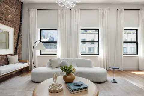 a living room with furniture and a chandelier