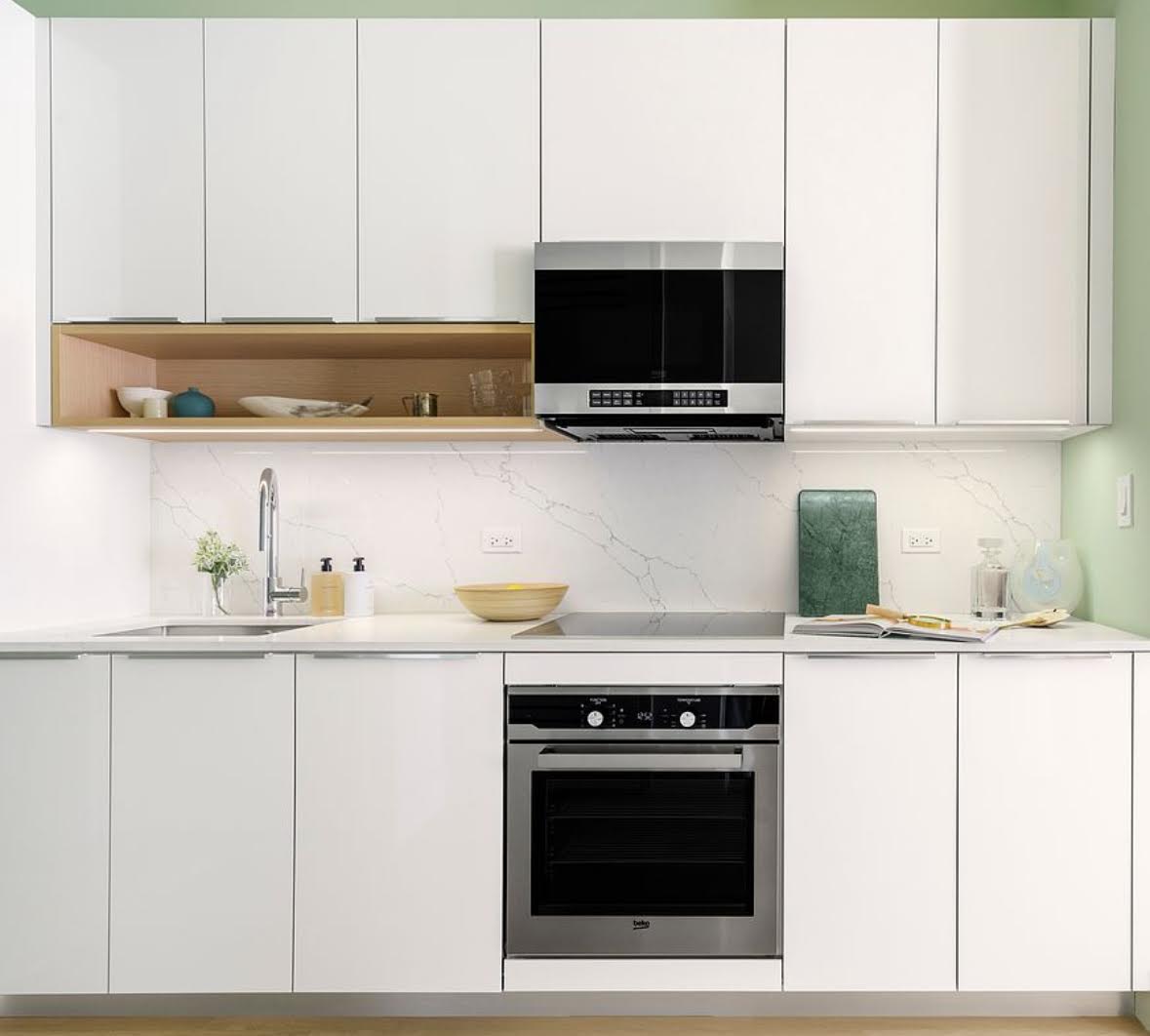 55 Broad Street, Unit 3202 Manhattan, NY 10004 - Photo 10 of 11 a kitchen with stainless steel appliances granite countertop a sink and a microwave