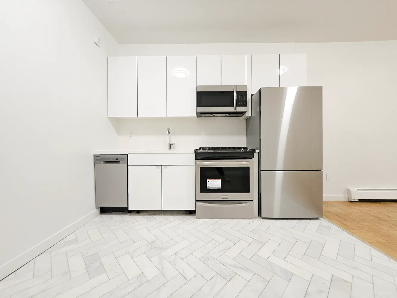 a kitchen with stainless steel appliances a stove a microwave and a refrigerator