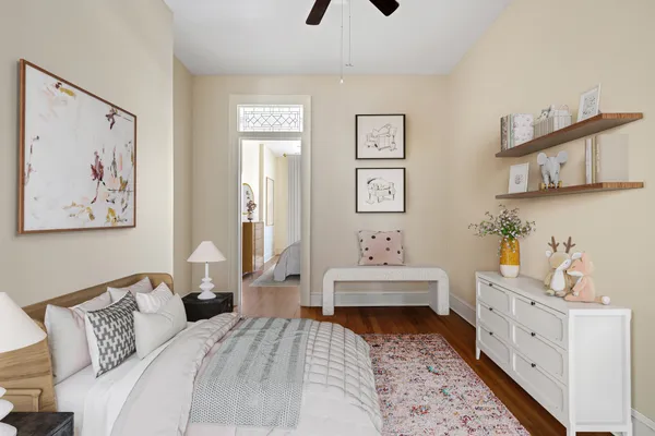 a bedroom with a bed and a lamp on dresser